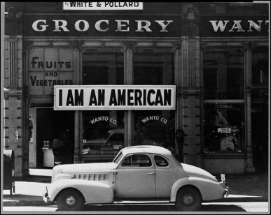   -Why did the Japanese-American owner of this grocery store hang a poster that declared his nationality the day after the attack on Pearl Harbor? A)  He wanted to encourage further immigration to the United States from Japan. B)  He wanted to announce his enlistment in the U.S. Army to fight against Japan. C)  He wanted to bolster American support for confining those of Japanese origin to internment camps. D)  He wanted to fight back against the perception that he was a traitor to the United States.