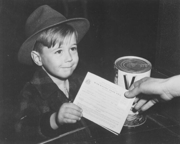     -These two photographs depicting American children shopping with ration books and collecting metal for local scrap drives during World War II reveal that . A)  scarcity impacted many American families B)  overproduction led to more expensive goods in markets C)  propaganda had little impact on American children D)  children played a marginal patriotic role on the home front