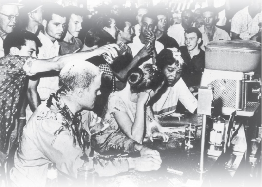   -What does this photograph of a sit-in at a Woolworth's lunch counter in Mississippi demonstrate about the power of nonviolent protest? A)  It encouraged outsiders to sit down and join in the protest. B)  It inspired the protesters' opponents to turn away from violence. C)  It protected the protesters from assailants. D)  It made the protesters' antagonists look unsympathetic to outsiders.
