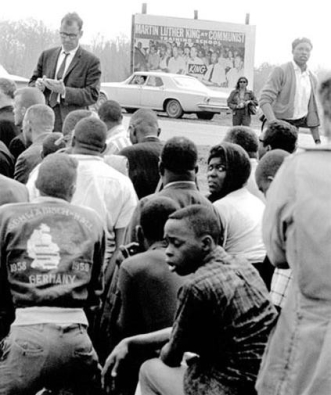 <strong> What was the purpose of this photograph that was taken on the march from Selma to Montgomery the week after Bloody Sunday and features civil rights protestors praying in front of a billboard claiming Martin Luther King Jr. was a communist?</strong> A) to show that King and his followers were devout Christians intent on promoting a democratic nation B) to demonstrate that, through prayer, these activists espoused nonviolent beliefs in advancing civil rights C) to ascertain that they had the First Amendment right of religious freedom despite the color of their skins D) to counter charges from ultra-conservative groups that the Civil Rights Movement was intentionally provoking violence so a communist revolution could take place