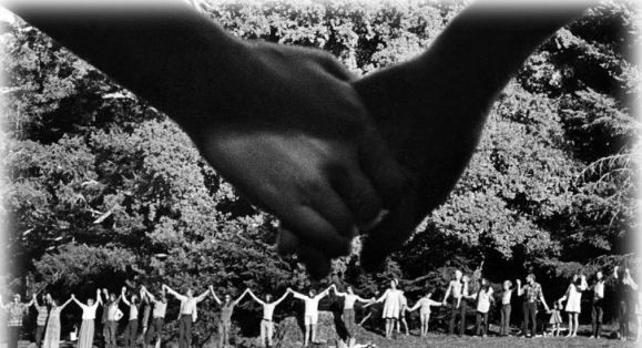<strong> The title of Robert Altman's photograph Holding Together refers to the hippies'</strong> A) fortitude as expressed by the setting in the wilderness B) strength in numbers as expressed by size of the gathering C) commitment to civil rights as expressed by their raised hands D) harmony as expressed by their joined hands