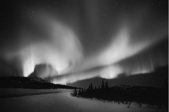 An aurora is produced when   A)  charged particles flow toward the magnetic poles and excite atmospheric gases. B)  swamp gases rise from the Arctic tundra and react with the upper atmosphere. C)  radiation in the Van Allen belts can be seen on a clear,cold night. D)  lightning travels from cloud to cloud rather than cloud to ground.