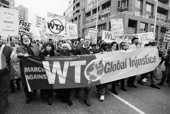Use the image below and your knowledge of world history to answer all parts of the question that follows. Protests against the World Trade Organization Seattle 1999   (A) Identify and explain ONE negative economic impact of globalization. (B) Identify and explain ONE positive economic impact of globalization. (C) Explain ONE cultural impact of globalization.