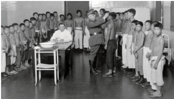 The image  Angel Island Physical Exam  shows a group of Chinese boys waiting to see the doctor while a military official inspects one of them. Viewed in the context of the history of Chinese immigration to the United States in the latter nineteenth century, which of the following conclusions can you draw from this image?   A)  Chinese immigrants were treated as individuals. B)  Immigration officials cared for the health and well-being of Chinese immigrants. C)  Immigration officials looked at Chinese as a threat to public health. D)  Chinese immigrants were grateful for getting to see a doctor upon their arrival.