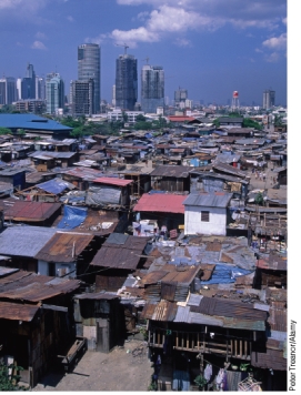 What does the image below represent and how does it relate to designing sustainable cities?   A) Residents of squatter community, like this one, must be evicted in order to achieve the goal of making cities more sustainable. B) Comparing the squatter community in the foreground to the skyscrapers in the back shows how a city can be transformed when sustainable city design is embraced as a goal for re-development. C) Squatter communities, due to their lower resource consumption, should be left unchanged as living in such conditions is compatible with the goals of sustainable living. D) Squatter settlements should be improved to provide basic service such as clean water to drink, sewage treatment, and garbage pickup so as to provide a better quality of life for the poorest of the poor.