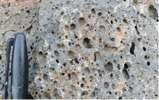119) What type of rock is shown in this photograph from the Investigation?   A) volcanic rocks, probably basalt B) granite C) metamorphic rocks D) sedimentary rocks