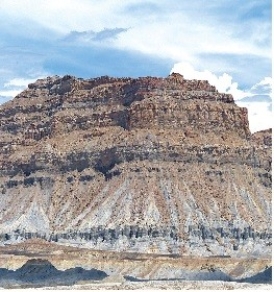 121) What type of rock likely composes the landscape shown in this photograph from the Investigation?   A) volcanic rocks, probably basalt B) granite C) metamorphic rocks D) sedimentary rocks