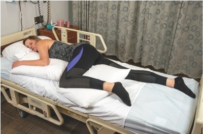 The nurse places a bed-bound client in the position shown. What other considerations would the nurse have for this client?   A)  Include a Trochanter roll to prevent of the neck. B)  Assess whether the client needs support to prevent foot drop. C)  Monitor for signs of increased intracranial pressure. D)  Place a rolled-up washcloth in the client's hands.
