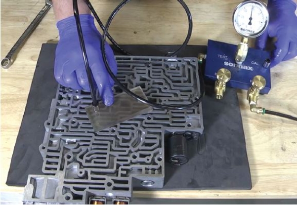 <strong>Identify the critical wear area of the valve body being tested in the given figure. </strong> A) Reverse abuse valve B) TCC regulator valve C) End plugs D) Sequence valve