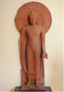   How does the representation of the Buddha that emerged in the second century CE, such as Yasadinna's standing Buddha (figure 18.11), to the use of recognizable attributes used to make figures in other religions always recognizable? Give specific examples, explaining how these attributes are similar and different. Why do you think different religions would have made certain figures recognizable with attributes? What does the fact that these similarities exist say about universal themes in art created by different people?