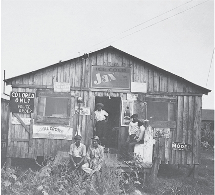   -What in this photo represents the indignity of segregation? A)  The ragged state of the shoppers' clothing B)  The rickety look of the building C)  The lack of goods for sale D)  The abuse by white neighbors that the shoppers endured