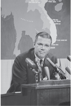   -Secretary of Defense Robert McNamara is shown here A)  Giving a press conference on Vietnam B)  Speaking at a university commencement C)  Giving the president a personal briefing on Operation Rolling Thunder D)  Promoting the Vietnam War among America's allies