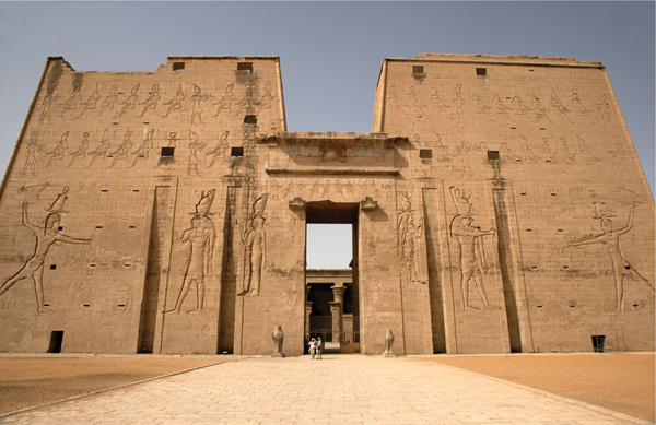 ​   How did Egypt's geography influence the design of the Great Pylon of the Horus Temple at Edfu ? A) The division between Upper and Lower Egypt is reflected in the upper and lower sections of the temple. B) Shifting sand dunes necessitated the protective barriers around the perimeter. C) The flow of the Nile probably inspired the direct path taken by worshipers through the temple. D) The waters of the Nile permitted the extensive use of waterworks throughout the temple complex.