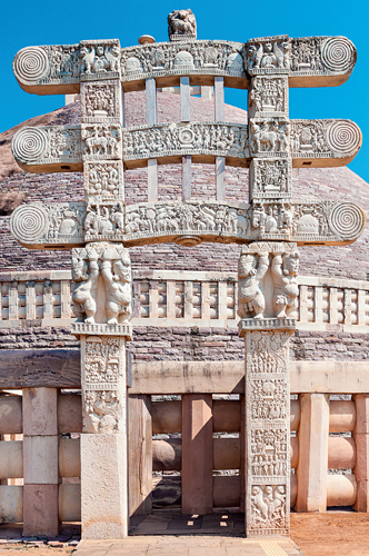 <strong> What term is used for the gateways surrounding a stupa mound?</strong> A) Triratna B) Torana C) Harmika D) Sangha