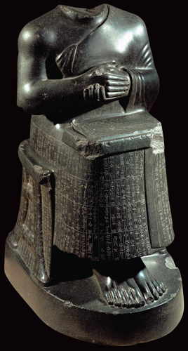 ​   What appears on the lap of the figure in this statue? A)  The gardens of Babylon B)  The colonnade at Persepolis C)  The name of the sculptor D)  A temple plan