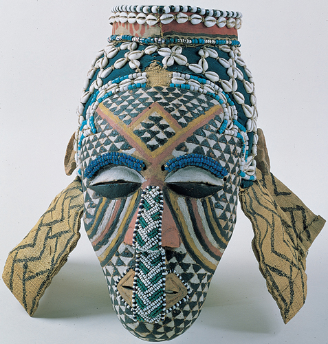 <strong> On this Kuba mask of the character Ngady Amwaash, what is represented by the stripes beneath the eyes?</strong> A) Scarification signifying status B) Tears of pain from childbirth C) Painted blood from symbolic blinding D) Colors of the character's lineage